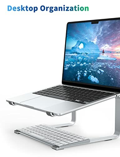 Laptop on stand with keyboard underneath for desktop organization