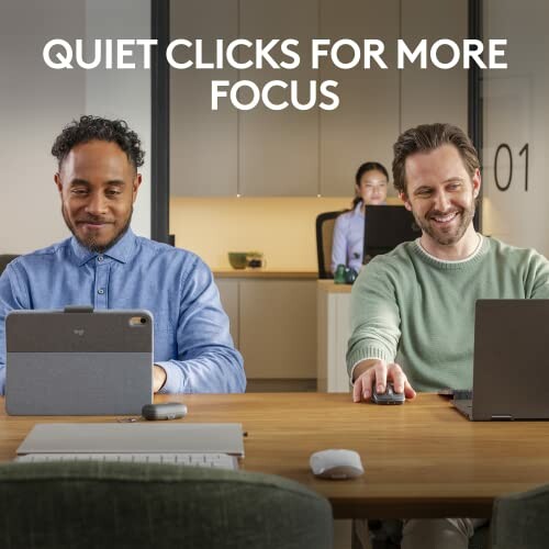 Two people working on laptops in a quiet office setting